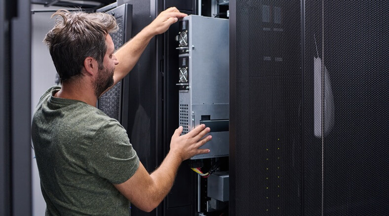 Engineer adjusting server rack in data centre